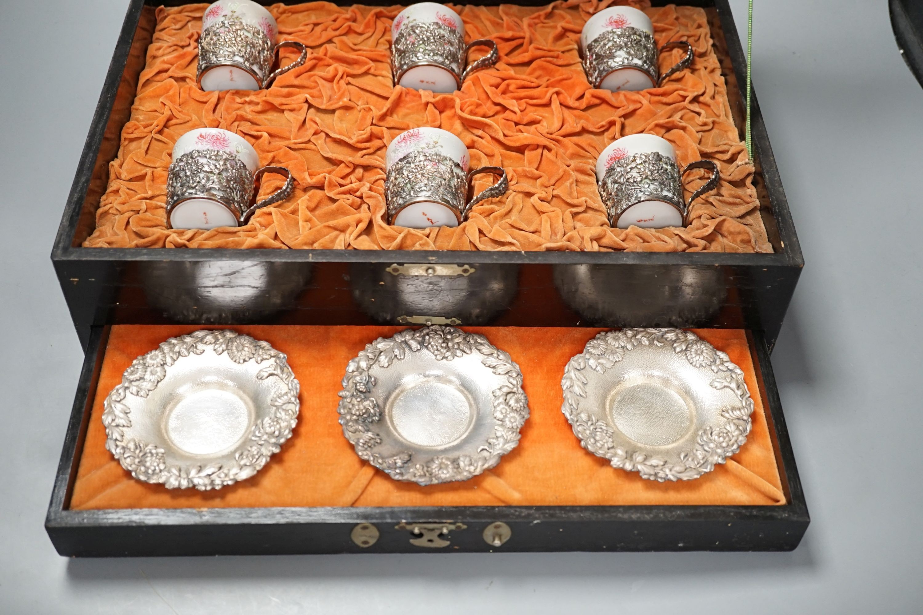 A cased Japanese white metal and eggshell porcelain six piece coffee set, maker’s mark only, case 39.5 cm wide